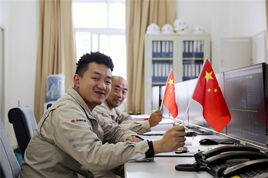 图2：新能源分公司广元漫天岭风电场运行人员正坚守在工作岗位上，手执国旗喜迎中秋国庆双节到来。.jpg